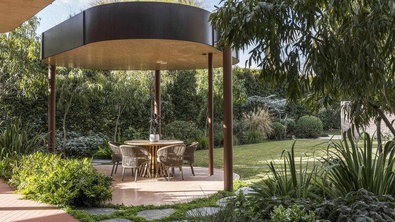 An alfresco area sits among lush landscaped gardens. Pic: Marshall White.
