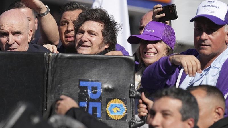 Police shielded Argentine President Javier Milei and his sister as objects were thrown at them. 