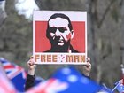 A man held a placard bearing the image of accused police-killing fugitive Dezi Freeman during Sunday’s anti-immigration protest.