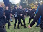 Black-clad men throw punches and kicks in a violent attack on an Aboriginal protest camp.
