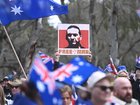 A man was seen holding a placard with an image of fugative Dezi Freeman at anti-immigration protesters march.
