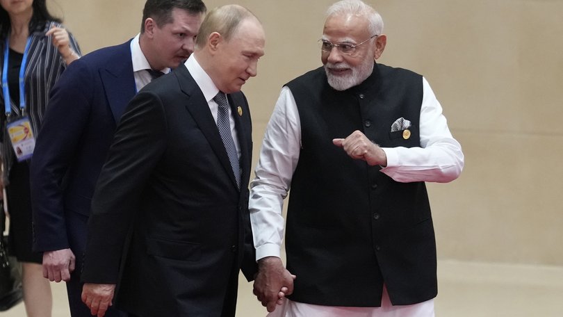Indian Prime Minister Narendra Modi walks next to Russian President Vladimir Putin.