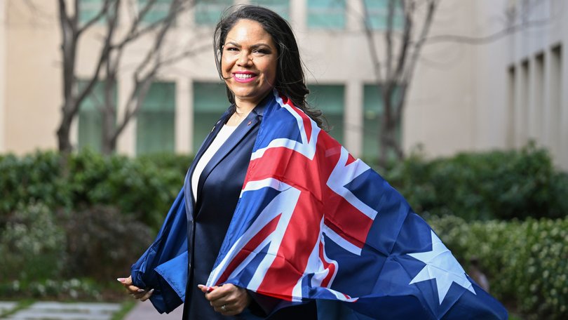 Jacinta Nampijinpa Price poses with an Australian Flag at Parliament House in Canberra.