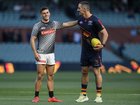 Nick Daicos of the Magpies greets Taylor Walker of the Crows during warm-ups.