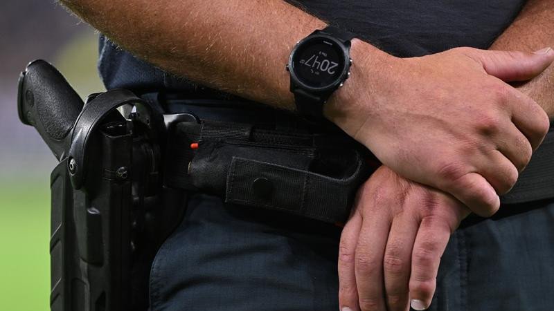 Police found loaded guns on two men during searches at an AFL game.
