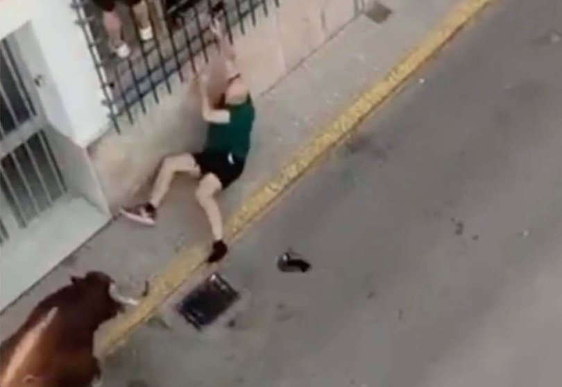 Horror sets in as the man gets knocked to the ground as the bull attacks.