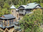 A Tamborine Mountain home complete with turrets, spires and curved stone walls is up for sale. Pic: Bartle Real Estate.
