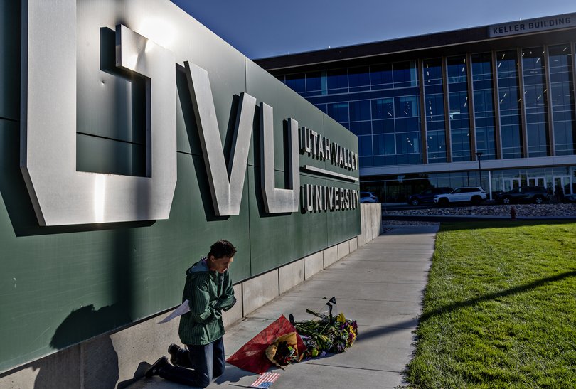 Wendy Lucas, a criminal justice student at Utah Valley University, prays next to a makeshift memorial.