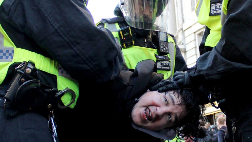 Police officers detain a protester during the Tommy Robinson-led Unite the Kingdom march.