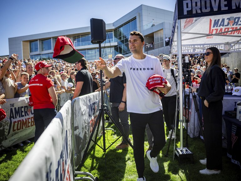Charlie Kirk hands out hats before speaking at Utah Valley University in Orem, Utah, Wednesday, Sept. 10, 2025. (Tess Crowley/The Deseret News via AP)