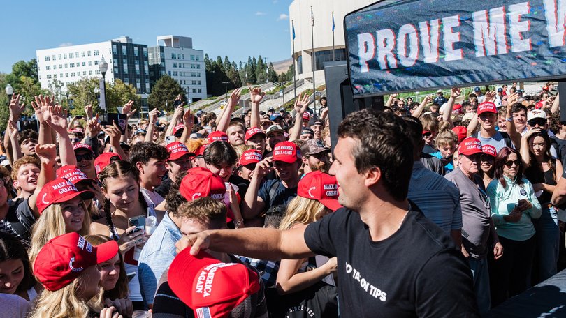 US conservative political activist and YouTuber, Charlie Kirk (C), founder of Turning Point USA, tosses MAGA hats as he arrives to speak at University of Nevada in Reno during his "You're Being Brainwashed" tour, October 8, 2024. (Photo by Andri Tambunan / AFP)