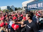 US conservative political activist and YouTuber, Charlie Kirk (C), founder of Turning Point USA, tosses MAGA hats as he arrives to speak at University of Nevada in Reno during his "You're Being Brainwashed" tour, October 8, 2024. (Photo by Andri Tambunan / AFP)