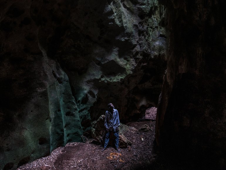 Lugadi Runya Shipa inside one of the caves in the Chasimba area of Kilifi County, Kenya, Oct. 15, 2024. For generations, men like him have guided worshipers through the caverns.