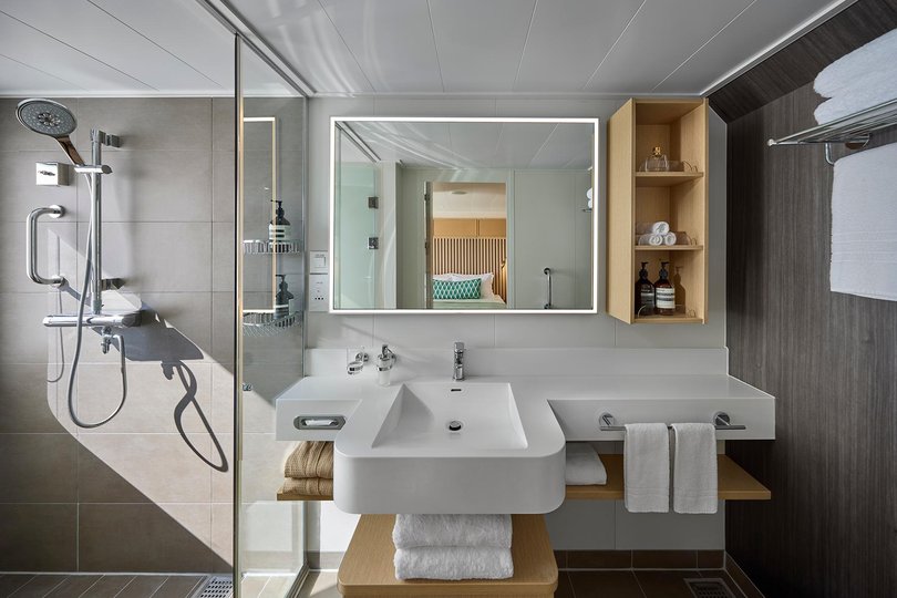 Interiors are brushed timber, brass, neutral linens.