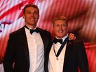 Matt Rowell of the Suns is presented the Brownlow Medal by prior winner Patrick Cripps.