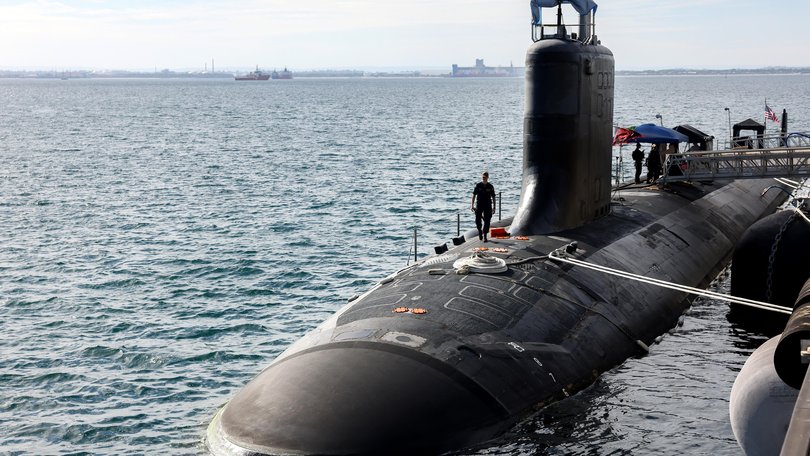 US Navy officers stand guard aboard Virginia-class fast attack submarine USS Minnesota after the vessel docked at HMAS Stirling on February 26, 2025 in Rockingham, Australia. 