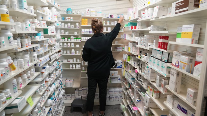 A pharmacy tech looks for a drug on a shelf inside a pharmacy in Utah, US.