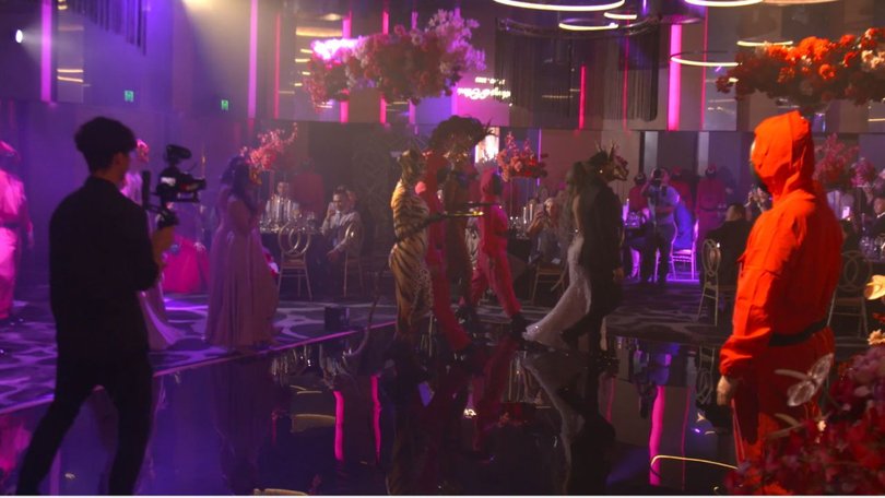 The newlyweds make a grand entrance dressed as VIPs, flanked by their bridal party in full guard regalia.
