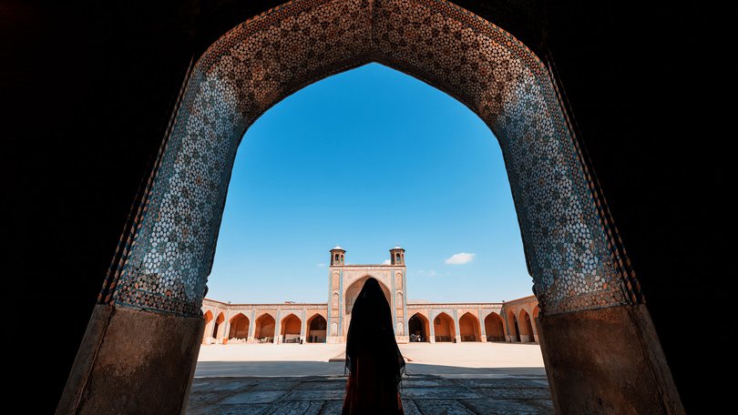 A Woman standing among the Ancient Mosque, Shiraz, Iran.