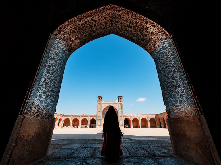 A Woman standing among the Ancient Mosque, Shiraz, Iran.
