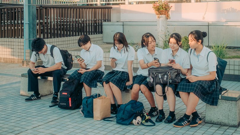 High schoolers in Toyoake, Japan look at their mobile phones on Sept. 29, 2025. Authorities in Toyoake introduced a rule limiting the use of digital devices to two hours per day outside of work and school. (Kentaro Takahashi/The New York Times)