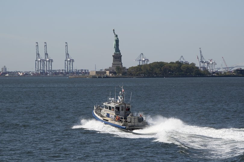 An NYPD patrol boat passes in front of the Statue of Liberty at Battery Park in New York on Wednesday.