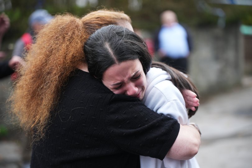 Members of the public react as they gather near the Heaton Park Hebrew Congregation Synagogue.