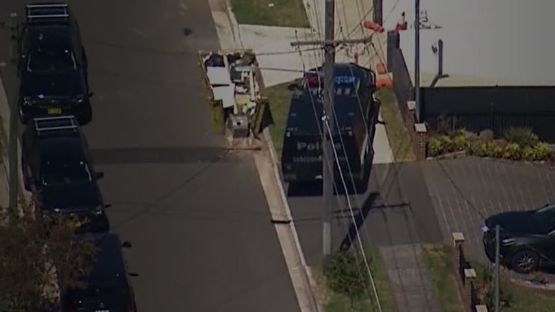 Police have surrounded a house and have called for the people inside to come out.
