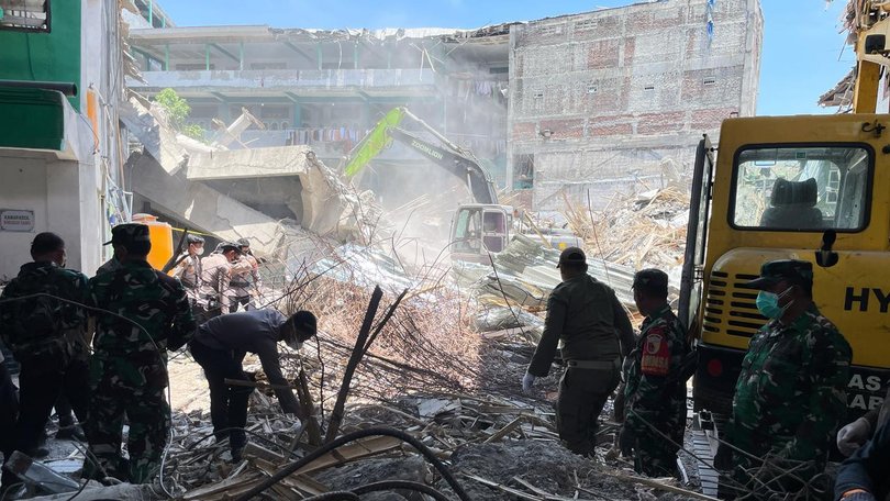 Rescuers clear rubble as they search for victims after a school building collapsed in East Java. (AP PHOTO)