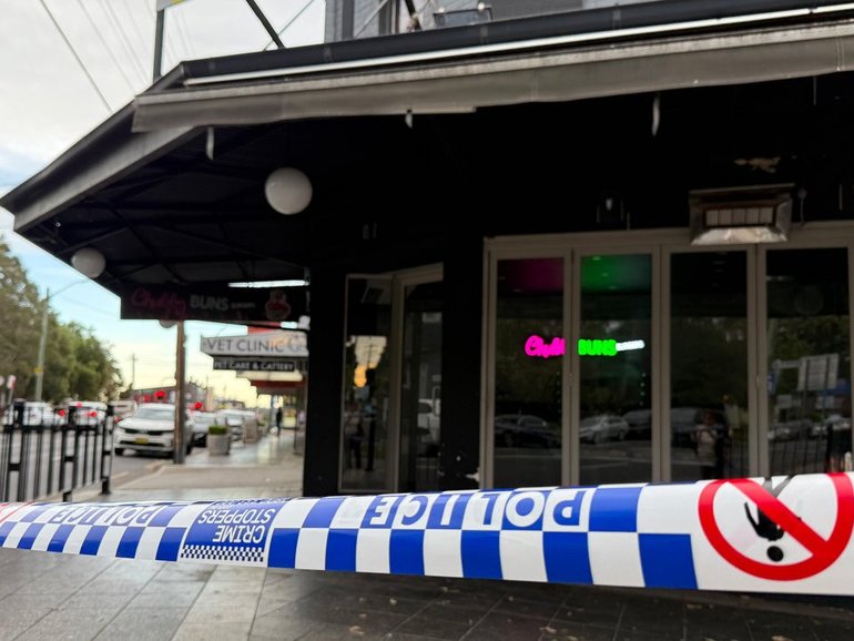 A man is under guard after up to 100 bullets were fired in a street, injuring multiple people. (Rounak Amini/AAP PHOTOS)