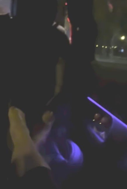 Markle with her feet up in the car as she was driven around central Paris at night. 