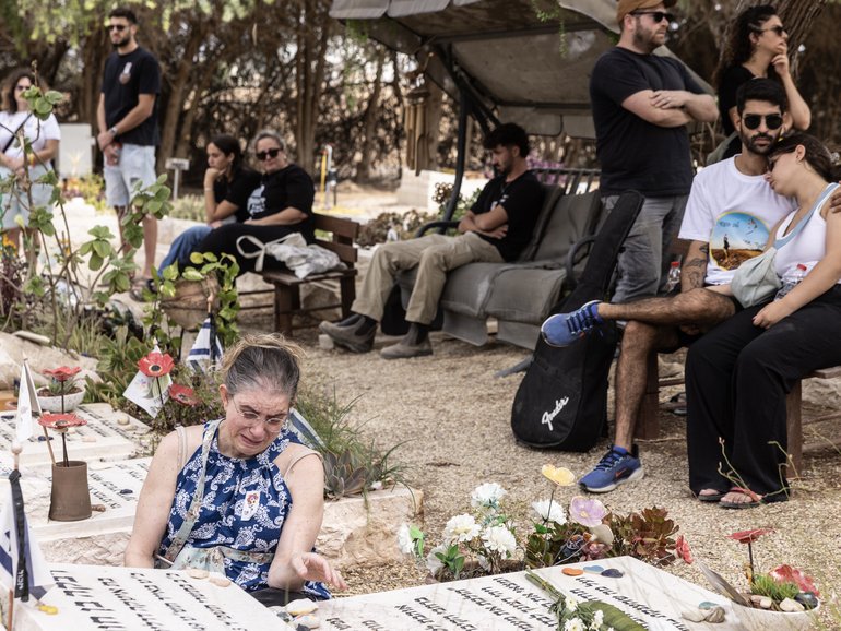 Relatives visit the graves of family members at Kibbutz Nir Oz on Monday. MUST CREDIT: Heidi Levine/For The Washington Post