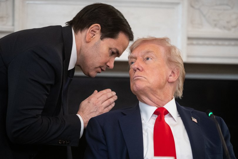 Marco Rubio hands Donald Trump a note and whispers in his ear. 