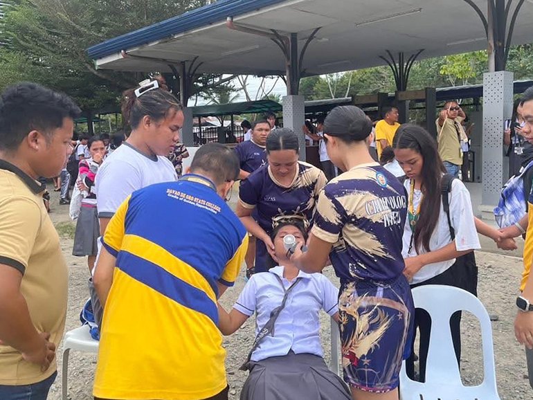 Students helping a fellow pupil as they gather outside the school buildings after an earthquake in Davao de Oro. 