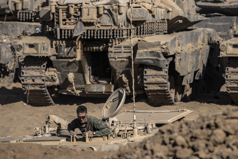 An Israeli soldier climbs out of an armored vehicle at a staging area just inside Israel, along the border with Gaza on Saturday, Oct. 11, 2025.