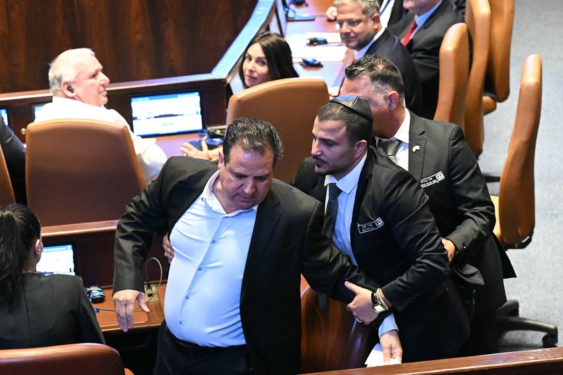 Israeli Knesset member Ayman Odeh is escorted out after holding a sign reading "Recognise Palestine" during a speech by US President Donald Trump at the Israeli parliament, the Knesset, on October 13, 2025 in Jerusalem.