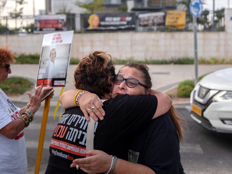 Sylvia Cunio, the mother of the two hostages, receives a hug after the announcement of a hostage exchange deal.