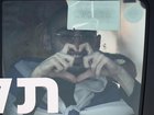 Rom Breslavski, an Israeli hostage released from the Gaza Strip smiles making a heart sign from a minibus at the Sheba Medical Center in Ramat Gan, Israel, Monday, Oct. 13, 2025. (AP Photo/Leo Correa)