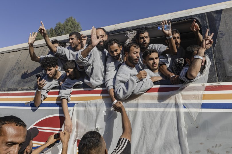 Palestinian prisoners released by Israel wave from a bus as they arrive at Nasser Hospital.