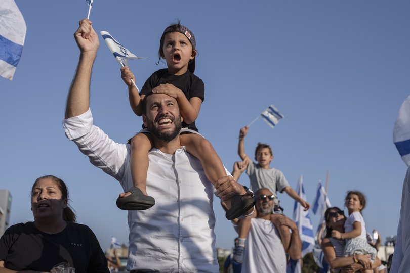 Crowds gather as a helicopter carrying hostages freed from captivity by Hamas in Gaza.