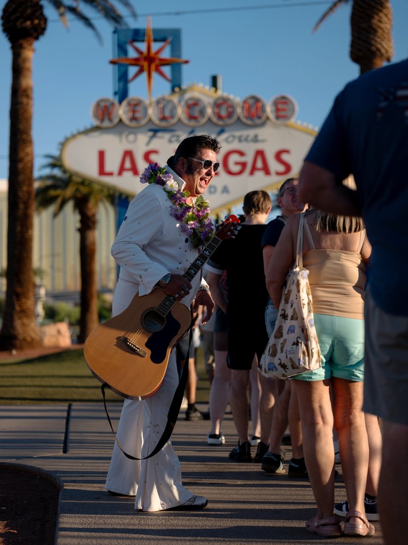 Elvis impersonator Mark Rumpler chats with visitors near the historic sign welcoming them to Las Vegas.
