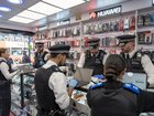 Police officers search a second-hand phone shop in London, September 25, 2025.