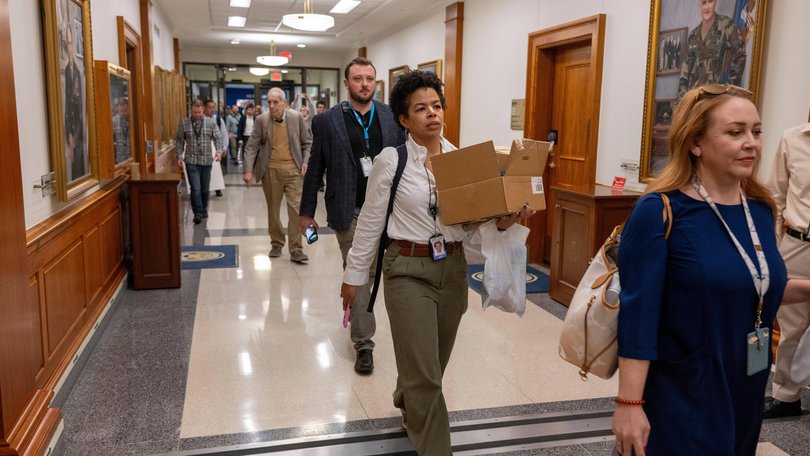 Members of the Pentagon press corp walk out of the Pentagon as a group after turning in their press credentials in Washington.