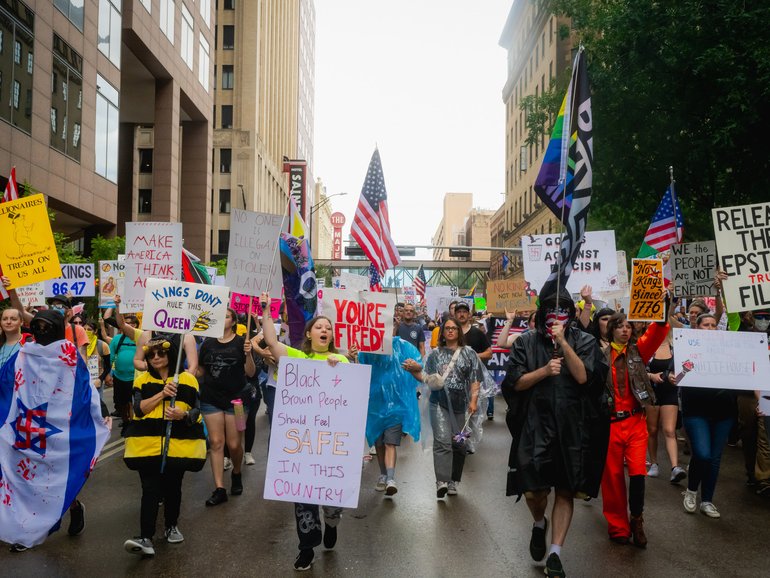 Demonstrators march through the streets of downtown despite heavy rain for the No King Day.