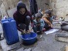 Sabah Abu Ghanem prepares food with her children in a makeshift kitchen in Gaza City.