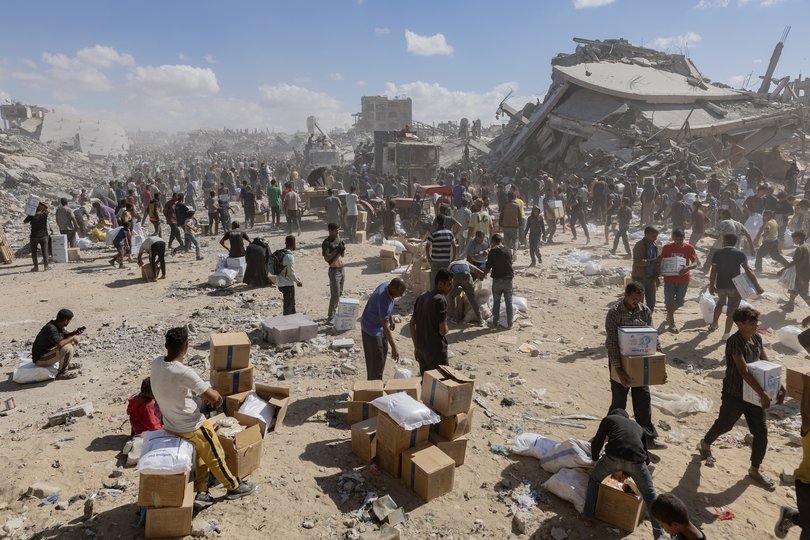 Palestinians with boxes of aid in Khan Younis in the southern Gaza Strip, Oct. 12, 2025.