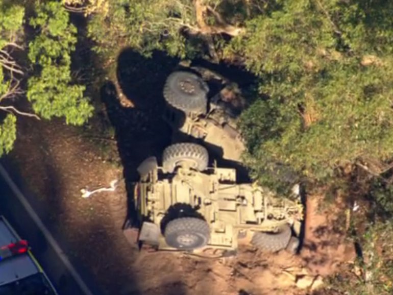 Rolled Army truck at the scene on Samford Road as emergency crews respond to the crash.