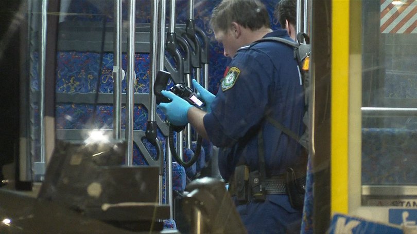 Police taking photos of the crime scene inside the bus.