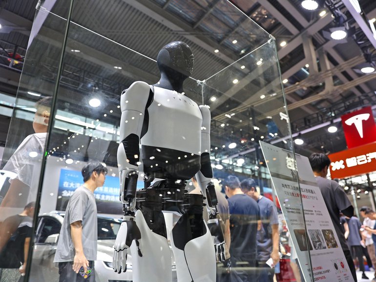 Tesla Optimus humanoids and Model Y L are displayed at the 2025 Shenzhen International Auto Show.