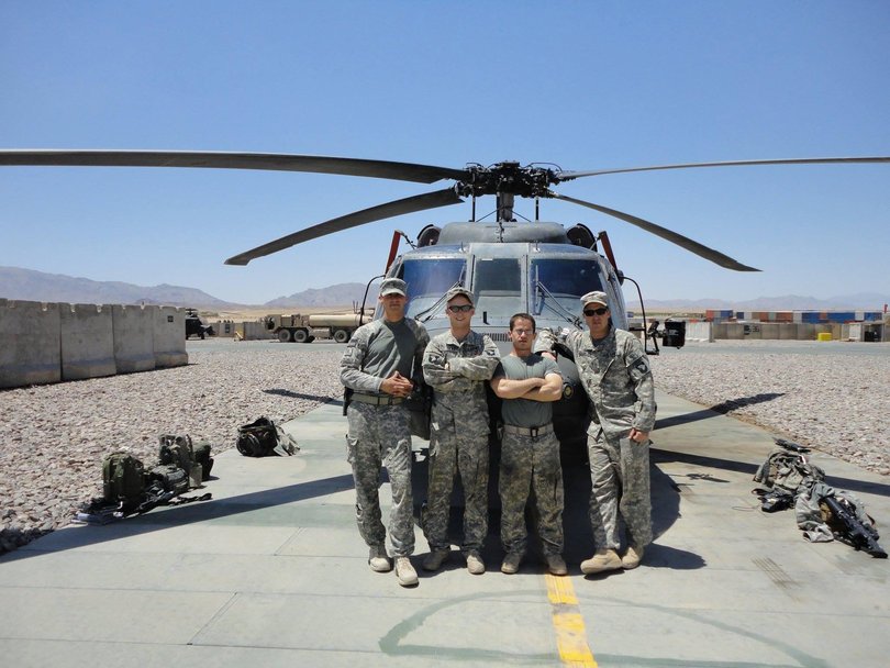US Army pilot Trevor Baucom, far right, and loadmaster Brandon Silk, second from left, in front of Black Hawk helicopter 448, which crashed in 2010, killing Staff Sergeant Silk and three Australian commandos, Tim Aplin, Scott Palmer and Ben Chuck.